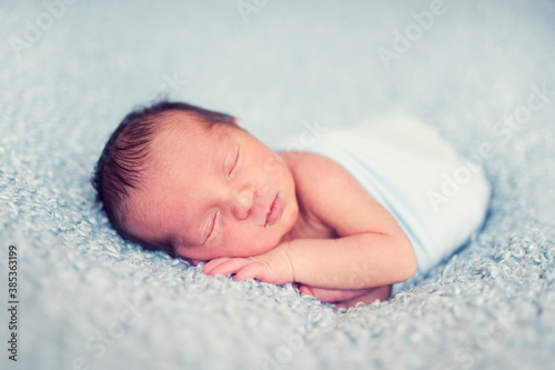 newborn baby sleeping on wool blanket. Happy baby in wrap, sleep time. 