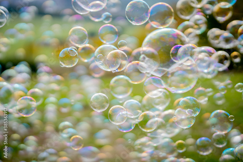 Image of soap bubbles on a sunny day on a green meadow. Background.