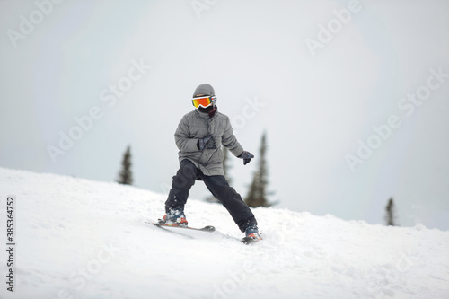 Skier in mountains on snowy slope