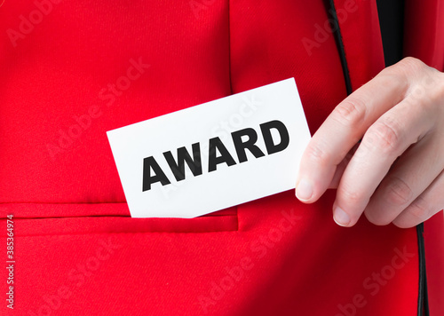 AWARDS word on the card in the hands of a businessman. close-up red jacket and hand.