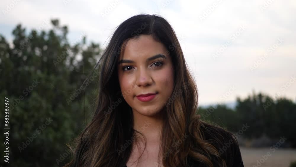 Attractive young independent adult hispanic woman looking with happy, smiling eyes at the camera with confidence and positivity for the future of human kind. Attractive young independent adult hispanic woman looking with happy, smiling eyes at the camera with confidence and positivity for the future of human kind.