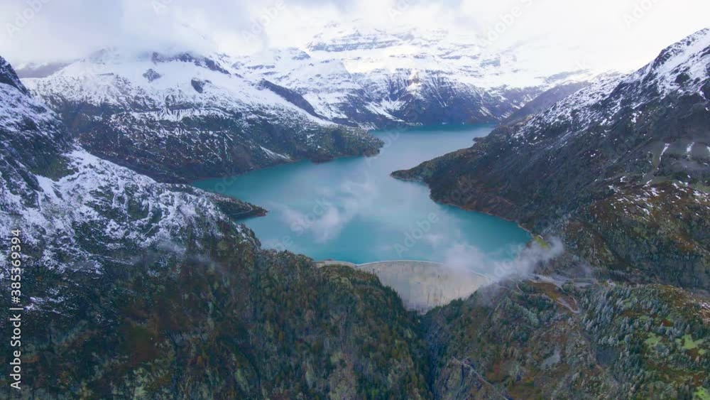 Hydropower generated from arch dam and reservoir lake in snow covered Swiss Alps mountains to produce renewable energy, sustainable hydroelectricity, aerial drone footage 4K video, autumn weather Hydropower generated from arch dam and reservoir lake in snow covered Swiss Alps mountains to produce renewable energy, sustainable hydroelectricity, aerial drone footage 4K video, autumn weather