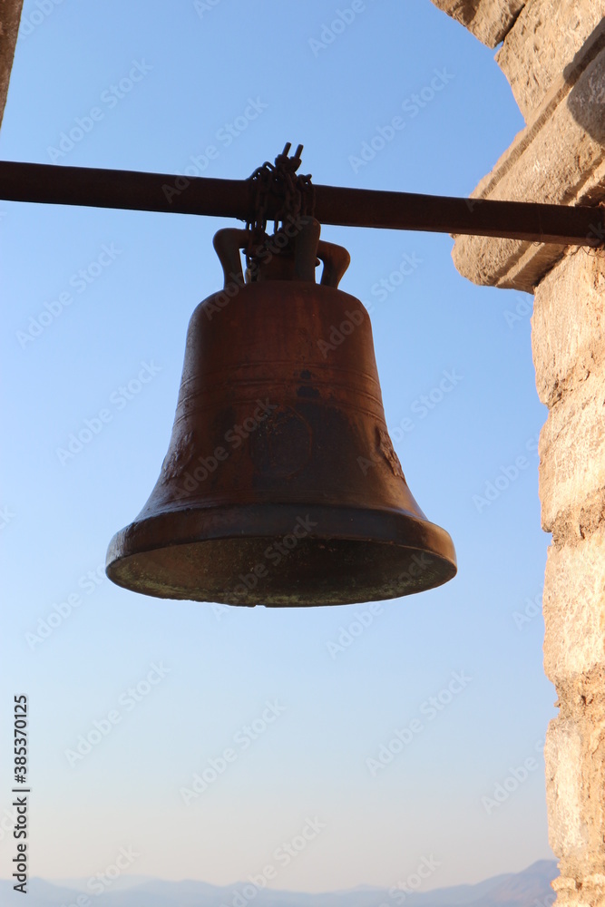 A metall bell with the blue sky as a background. The earliest metal bells were found in China. Bells were also used in ancient Greece and Rome. Today they are mostly used for religious reasons. 