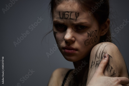 Fototapeta Naklejka Na Ścianę i Meble -  woman with offensive inscriptions on her body touching herself with hands stress frustration hate