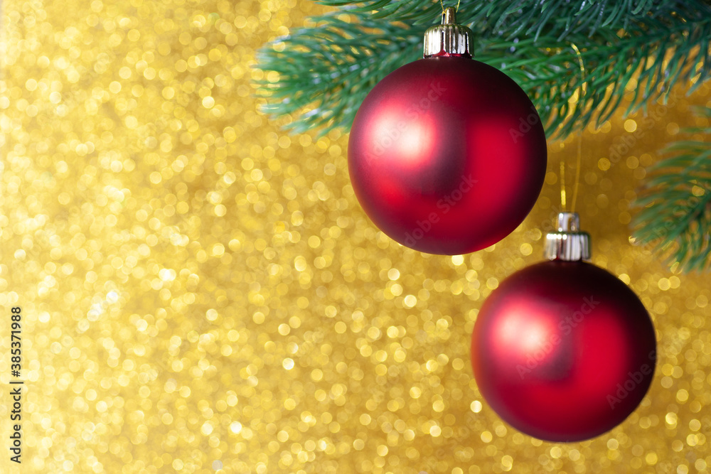 two red shiny ball on a new year tree branch on a yellow blurred background, mock up.