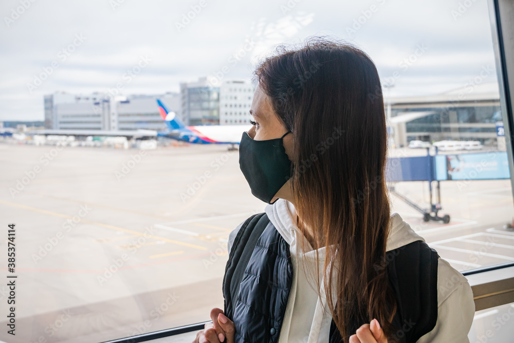 Fototapeta premium Woman wearing a mask for prevent virus in international airport. Protection against Coronavirus and COVID-19