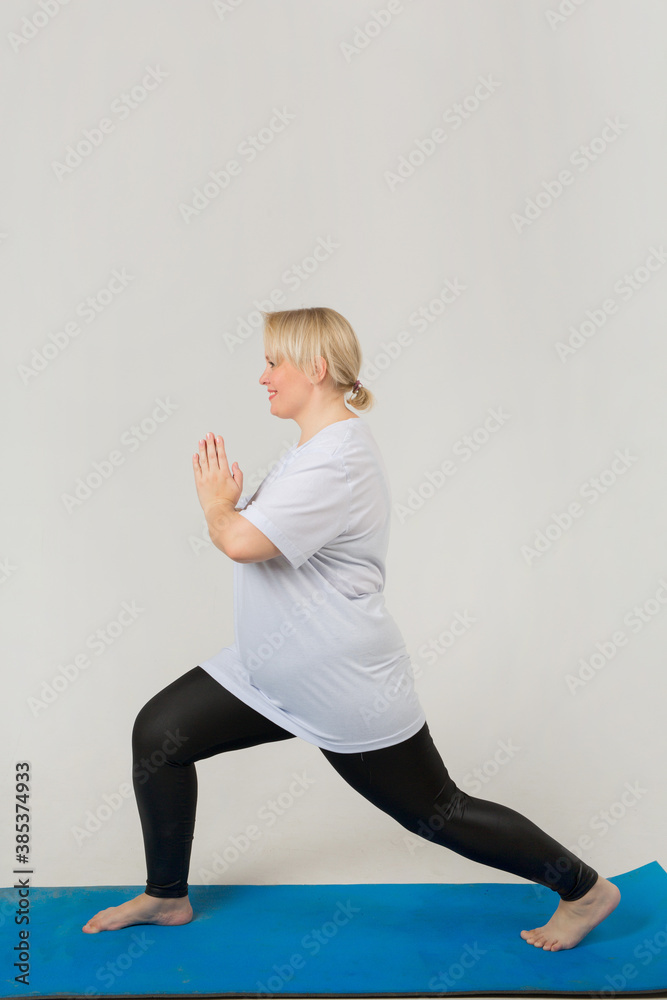 Naklejka premium beautiful young plump female in a white t-shirt goes in for sports on a white background
