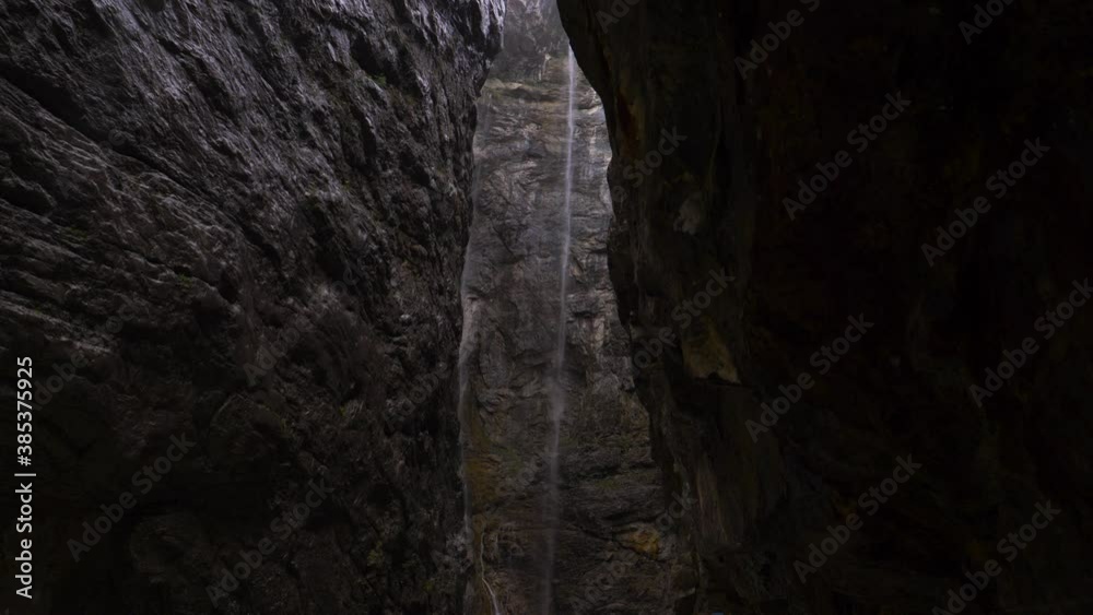 glacier canyon with raging fast flowing river and high Waterfall. Narrow Mountain walls during foggy cloudy rainy day in Grindelwad, Switzerland glacier canyon with raging fast flowing river and high Waterfall. Narrow Mountain walls during foggy cloudy rainy day in Grindelwad, Switzerland