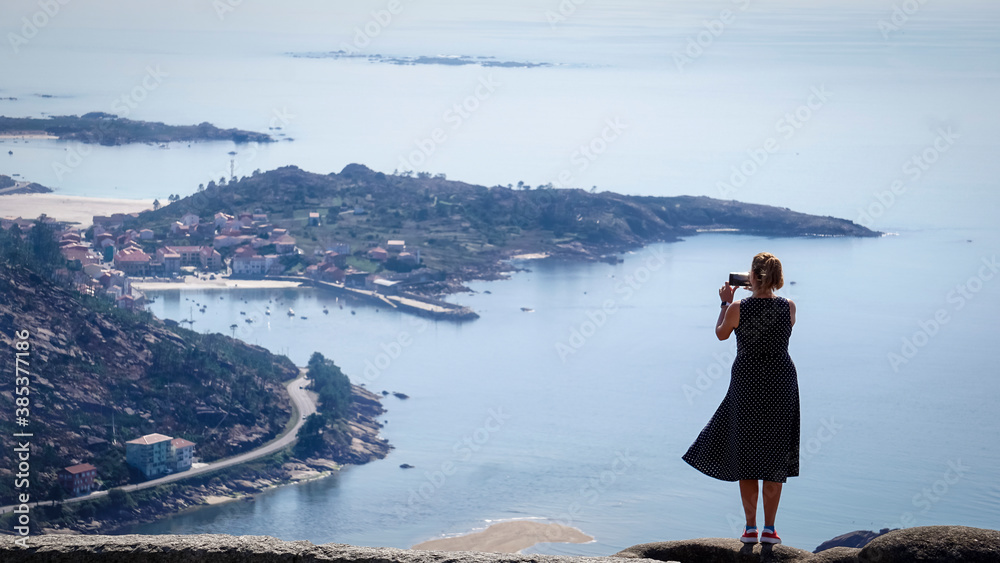 woman taking photos at the ezaro viewpoint in dumbria, la Coruña woman taking photos at the ezaro viewpoint in dumbria, la Coruña