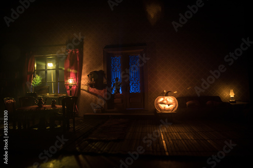 A realistic dollhouse living room with furniture and window at night. Artwork table decoration with handmade realistic dollhouse. Selective focus.