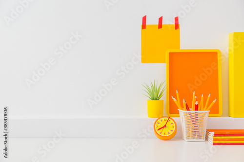 Fotografia Student creative desk mock up with colorful office supplies and blue wall