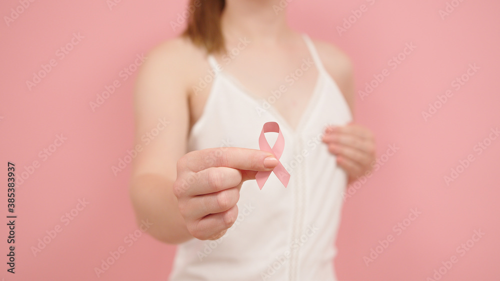 Pnk october, brest cancer awareness ribbon in the hand of a young unrecognzable woman. High quality photo Pnk october, brest cancer awareness ribbon in the hand of a young unrecognzable woman. High quality photo