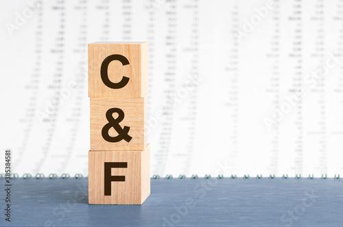 text c f on vertical row of wooden blocks on the background of columns of numbers photo