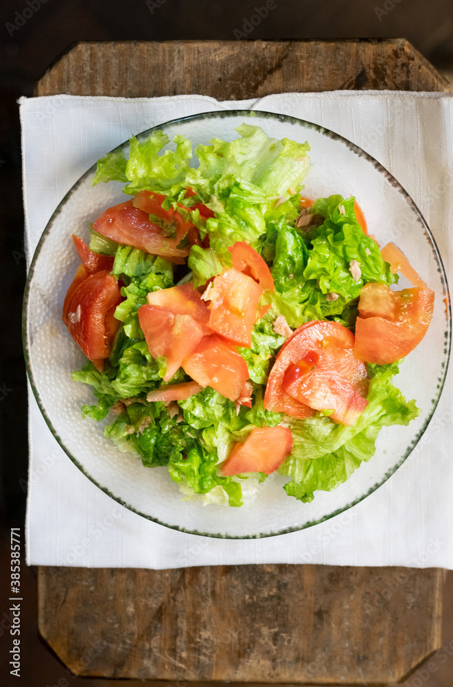 Plato de ensalada de tomate y lechuga con servilleta de papel de cocina. Plato de ensalada de tomate y lechuga con servilleta de papel de cocina.