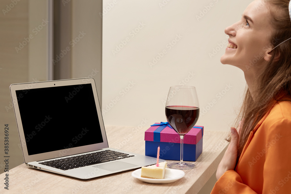 A young woman communicates online via video link on her birthday. Birthday celebrations during the pandemic. A young woman communicates online via video link on her birthday. Birthday celebrations during the pandemic.