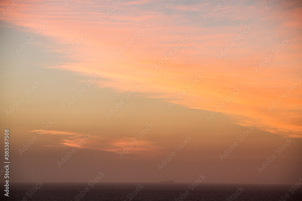 sun setting on the horizon the water of the caribbean sea and a boat with people