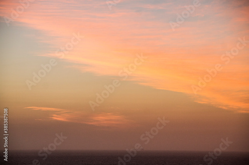 sun setting on the horizon the water of the caribbean sea and a boat with people
