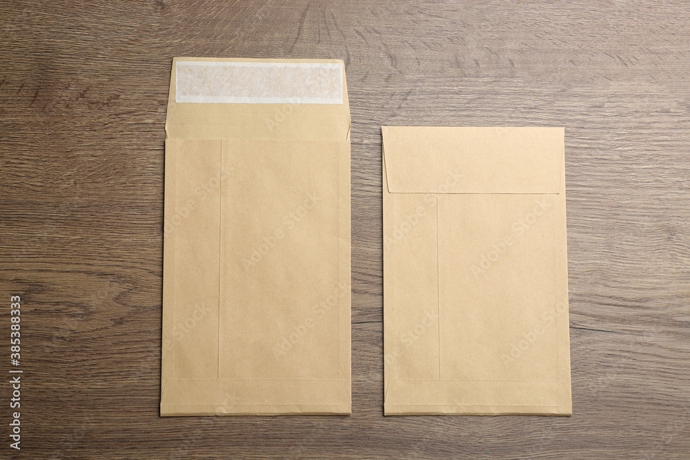 Kraft paper envelopes on wooden background, flat lay