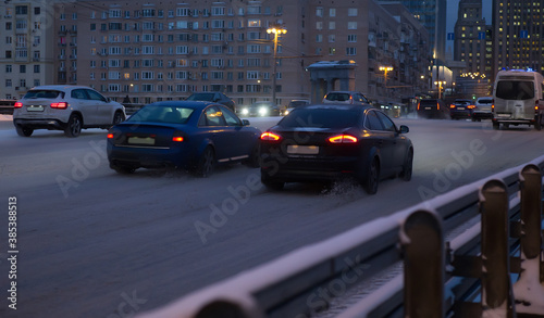 Cars move in the winter at night on the bridge