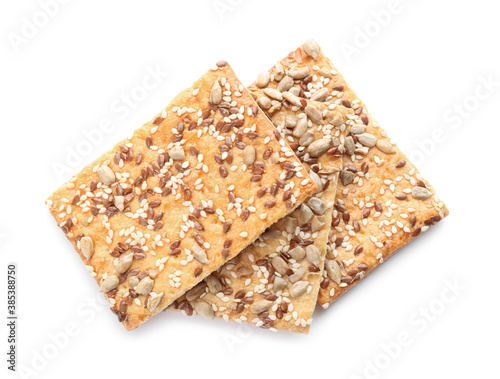 Delicious crispy crackers with different seeds isolated on white, top view