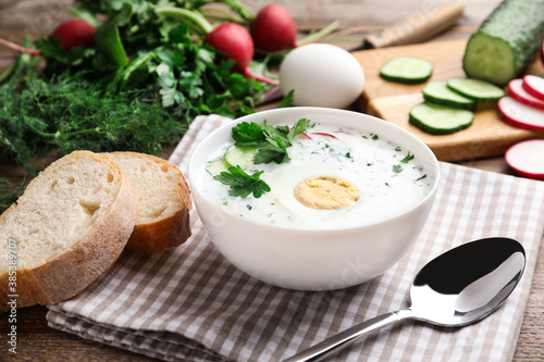 Delicious cold summer soup with kefir served on wooden table