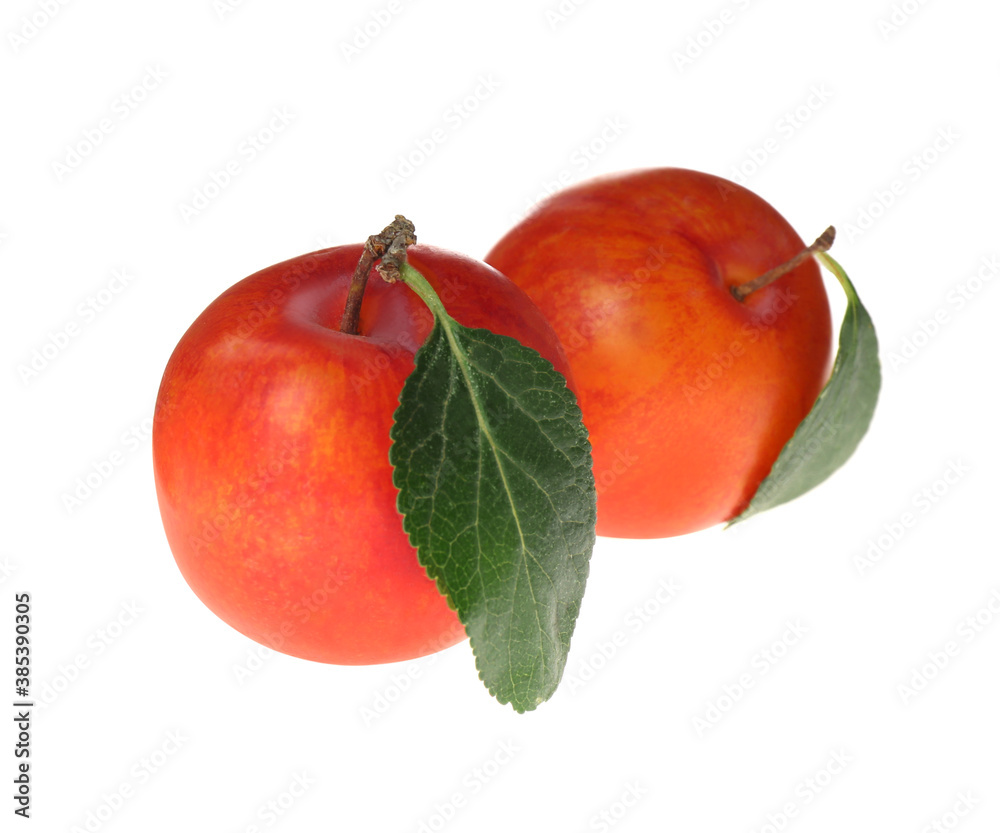 Delicious ripe plums with leaves isolated on white Delicious ripe plums with leaves isolated on white