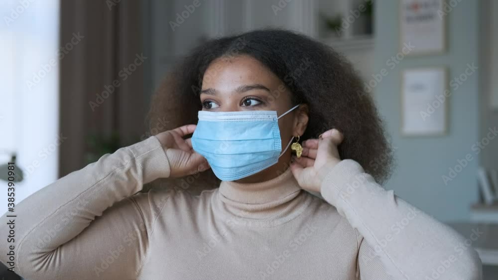 young woman portrait putting on medical mask at home young woman portrait putting on medical mask at home