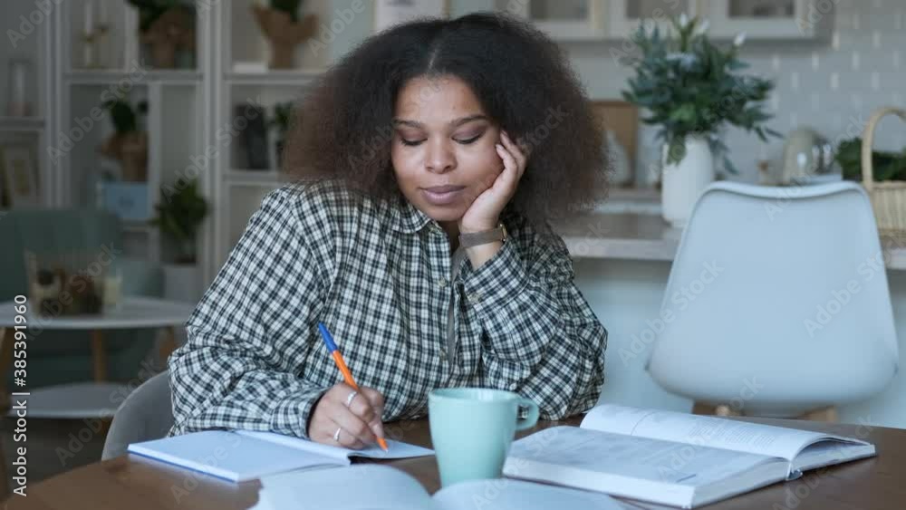 dreamy woman student making notes in notebook at home dreamy woman student making notes in notebook at home