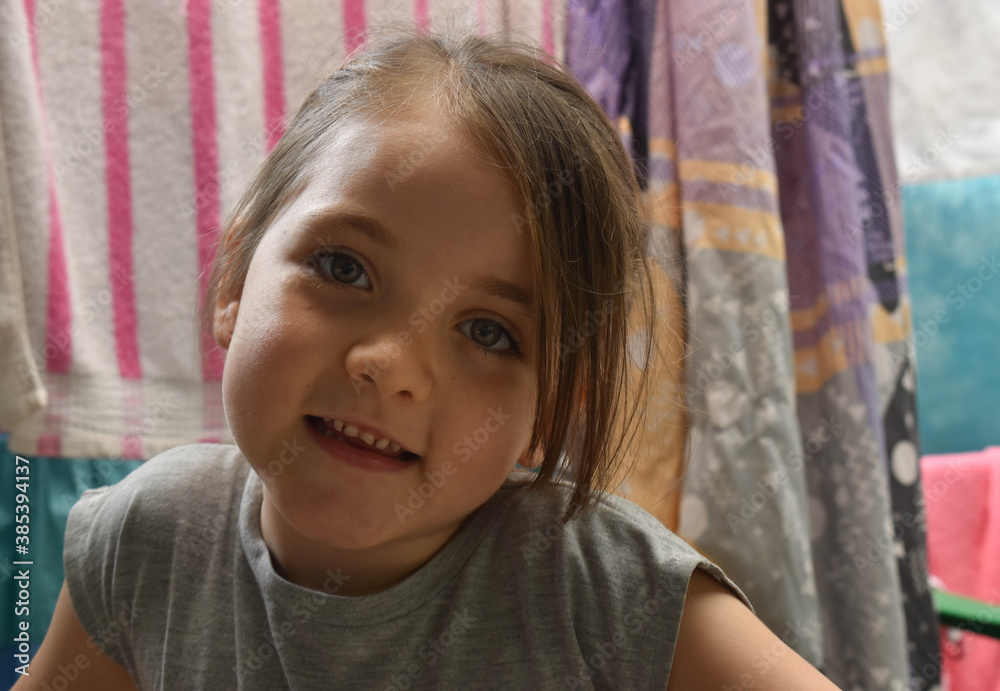 HERMOSA NIÑA COLOMBIANA DE OJOS CLAROS SONRIENDO. FONDO DE SABANAS DE COLORES COLGANDO HERMOSA NIÑA COLOMBIANA DE OJOS CLAROS SONRIENDO. FONDO DE SABANAS DE COLORES COLGANDO