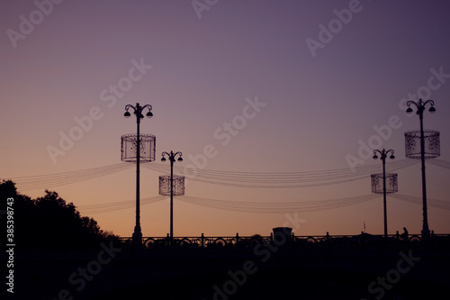 sunset in the city with lights decorations silhouette