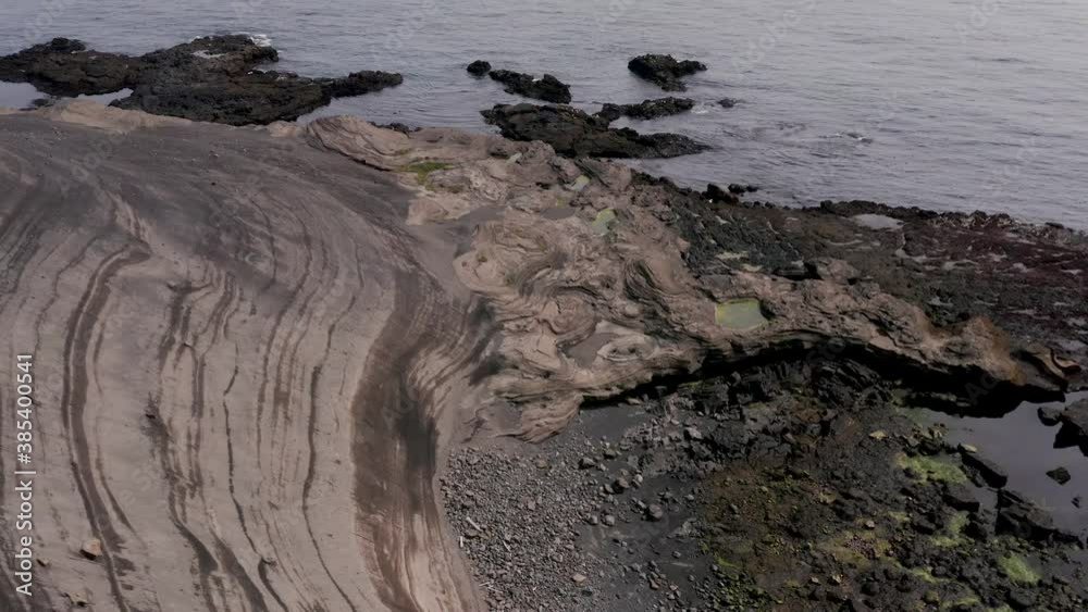 Grey coastal textures formed by years of solidified lava from nearby volcano Grey coastal textures formed by years of solidified lava from nearby volcano