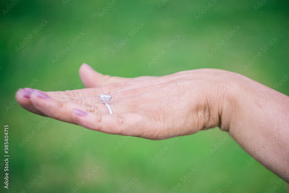 Hand of newly engaged woman displaying diamond ring