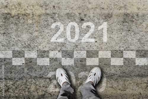 Welcome 2021 - Goodbye 2020 - Man stands in front of a start New Year 2021.