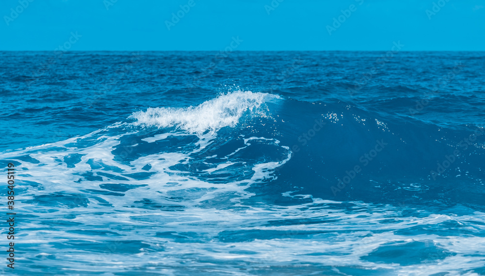 Water wave splash on blue sea background.