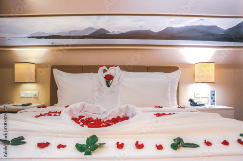 Towel swans and rose flower on bedroom for honeymoon couple 