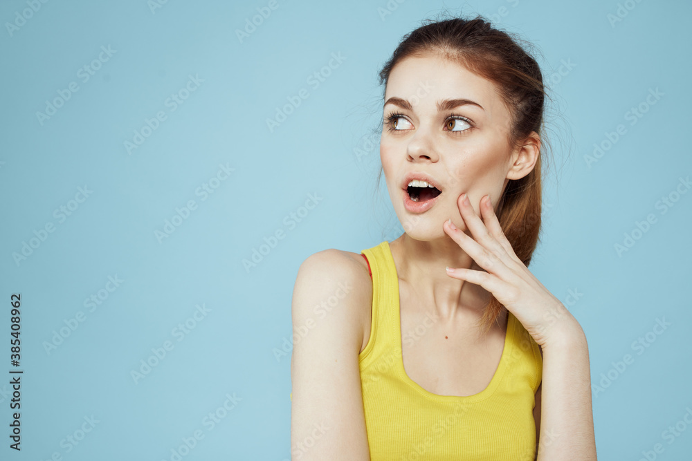 Sportive woman yellow tank top pigtail towards fitness blue background Sportive woman yellow tank top pigtail towards fitness blue background