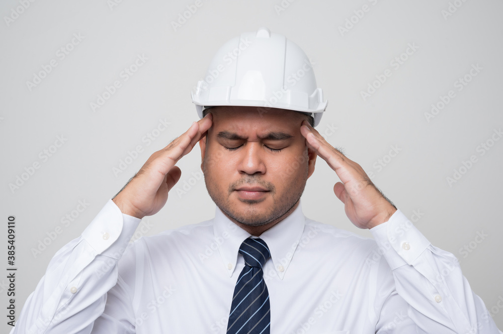 Young asian civil engineer helmet hard hat standing and headache hands in head feeling depressed on isolated white background. Mechanic service concept. Young asian civil engineer helmet hard hat standing and headache hands in head feeling depressed on isolated white background. Mechanic service concept.