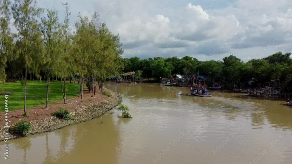 Follow wooden SE Asian fishing boat along canals polluted dirty waters Follow wooden SE Asian fishing boat along canals polluted dirty waters