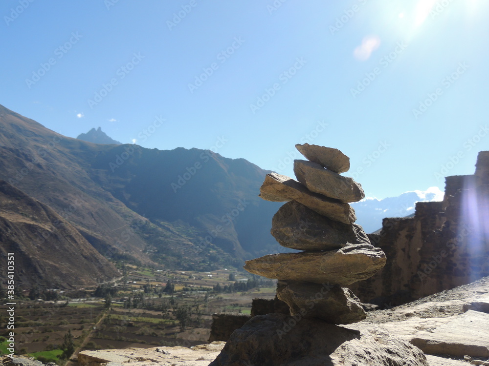 A rock balancing with the sacred valley in the background.