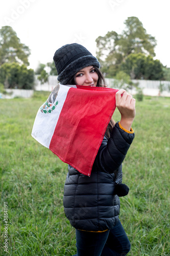 Happy young woman with flag of mexico celebrating