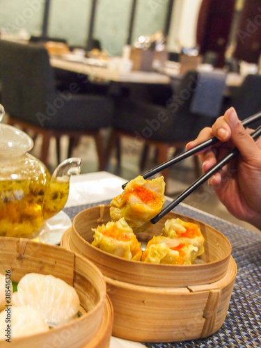 Picking up a siew mai (dim sum) with chopsticks