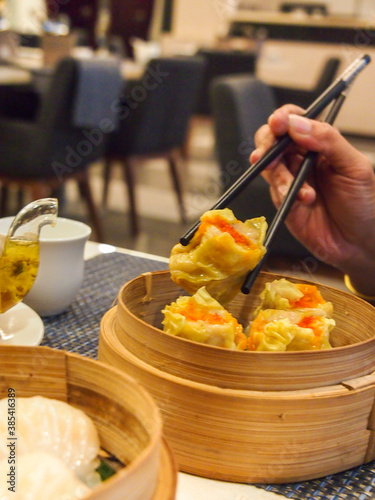 Picking up a siew mai (dim sum) with chopsticks