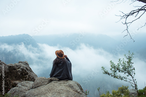 Mujer sentada de espaldas observando el paisaje