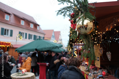 Christmas market in Germany. Christmas holidays in Germany.People at the Christmas market  on a traditional German style fachwerk houses background.Christmas and New Year in Europe © Yuliya