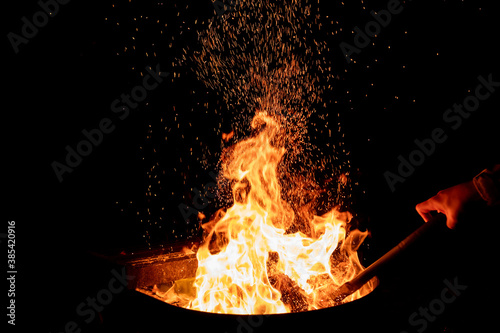 Fire in a fire pit at night. Sparkles fly high
