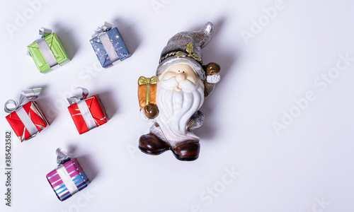 Christmas composition, Santa Claus or gnome surrounded by Christmas gifts on a white background, flat lay, top view
