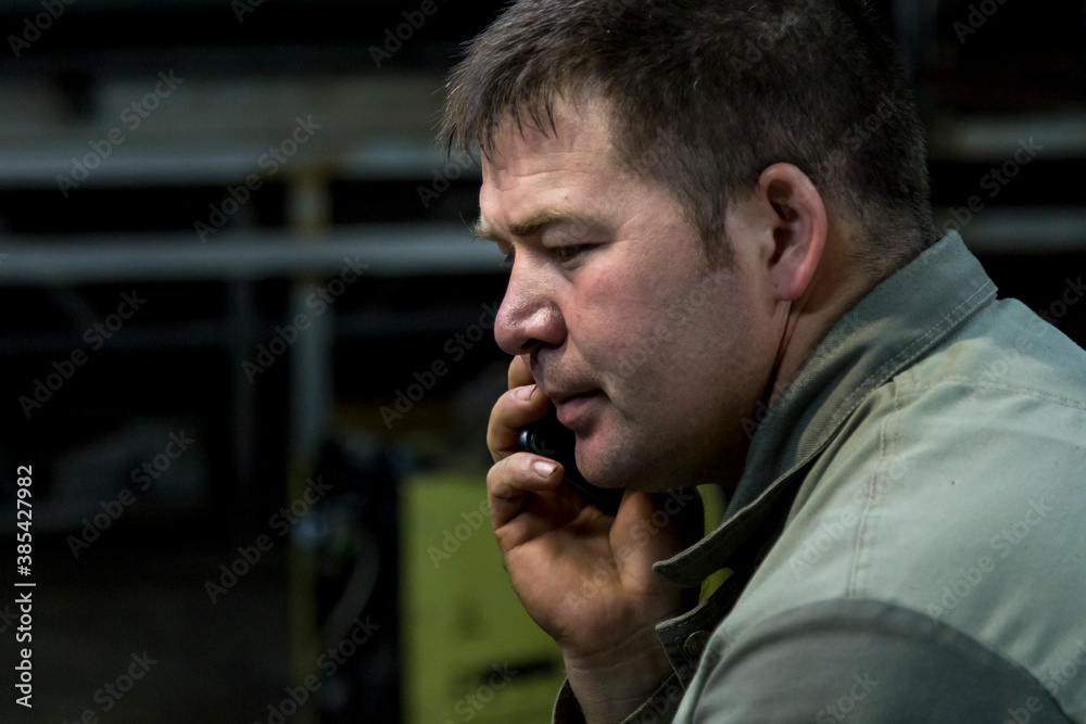 Close-up portrait of a man in the workplace with a mobile phone Close-up portrait of a man in the workplace with a mobile phone