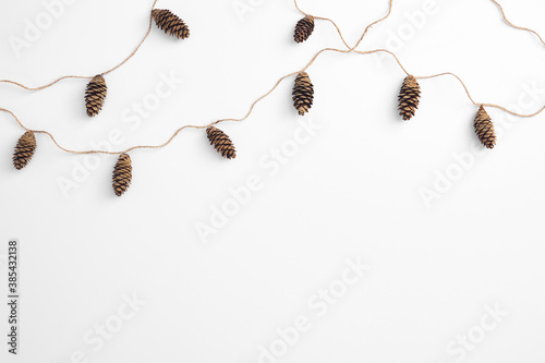 Zero waste christmas garland made from pine cone and natural jute twine. Horizontal composition, flat lay, top view. Eco friendly minimal christmas top mockup.