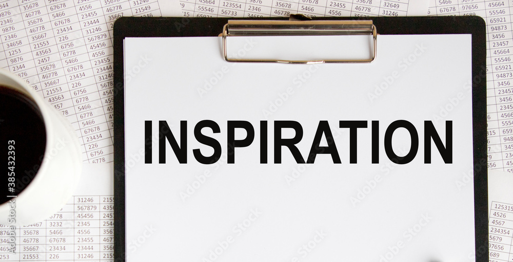 Text on a tablet with INSPIRATION paper, a number of coffee and reports. Text on a tablet with INSPIRATION paper, a number of coffee and reports.