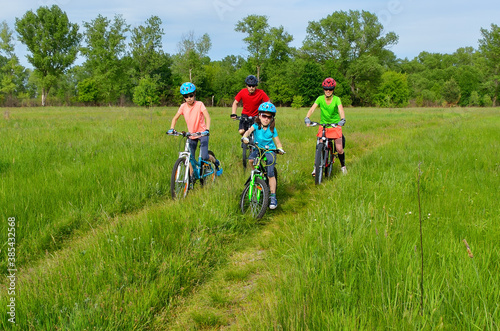 Happy family on bikes, spring cycling outdoors with kids 